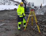 scan survey staff member working on a total station during winter