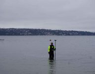 staff member gathering height measurements in lake