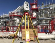 scan survey staff member using a total station at a construction site